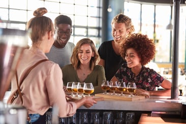 waitress-serving-group-of-friends-beer-tasting-in-H79VPE5